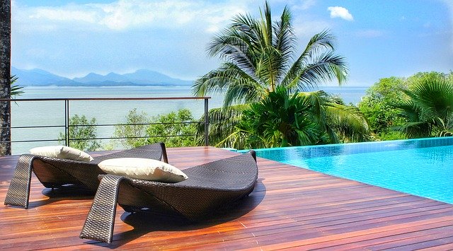 Saltwater pool overlooking sea with mountains in the background